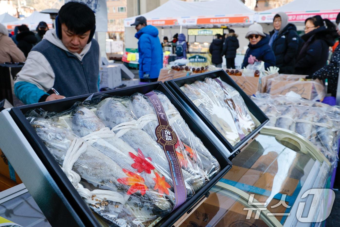 본문 이미지 - 설 연휴를 일주일 앞둔 7일 서울 서대문구 홍제폭포광장에서 '2026년 서대문구 설맞이 직거래장터'를 찾은 구민들이 굴비를 고르고 있다. 이번 행사에는 전국 31개 지자체에서 60여곳의 생산자 단체가 참여해 한우, 사과, 배 등 제수용품과 굴비, 더덕 등 명절선물용품을 판매했다. 2026.2.7 ⓒ 뉴스1 안은나 기자