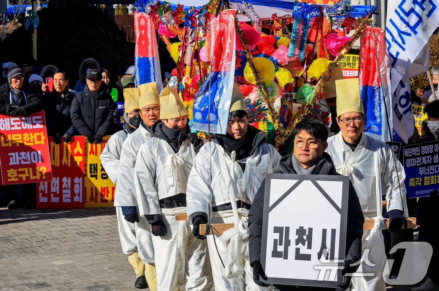 본문 이미지 - 과천경마공원 이전반대 비상대책위원회가 7일 경기 과천 중앙공원 분수대 앞에서 열린 '과천경마공원 이전 반대 집회'에서 상여 퍼포먼스를 하고 있다. 2026.2.7 ⓒ 뉴스1 이호윤 기자