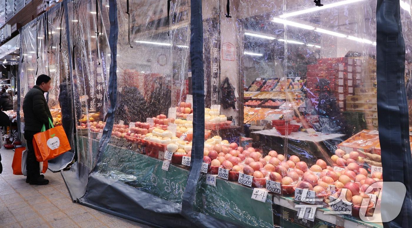 본문 이미지 - 8일 서울 동대문구 청량리종합시장의 한 과일 점포에서 한파로 과일이 얼지 않도록 바람막이가 설치돼 있다. 2026.2.8 ⓒ 뉴스1 박지혜 기자