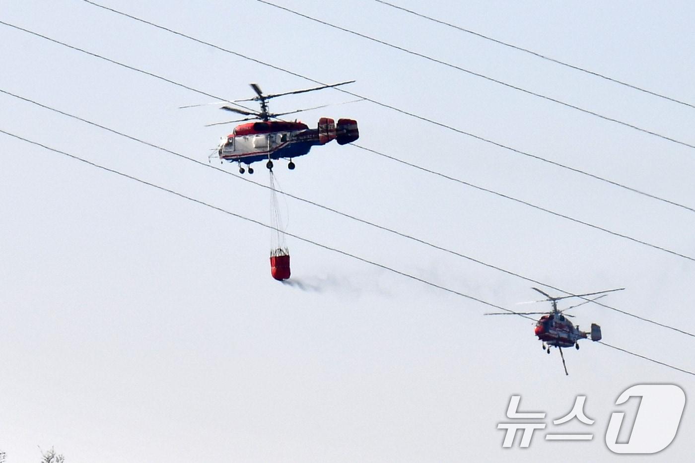 본문 이미지 - 8일 오후 경북 경주시 문무대왕면 입천리의 산불이 강풍을 타고 확산되는 가운데 산불 진화헬기들이 송전선로를 피해 진화 작업을 벌이고 있다. 이날 오후 정부는 신속한 진화를 위해 국가소방동원령을 발령했다. 2026.2.8 ⓒ 뉴스1 최창호 기자