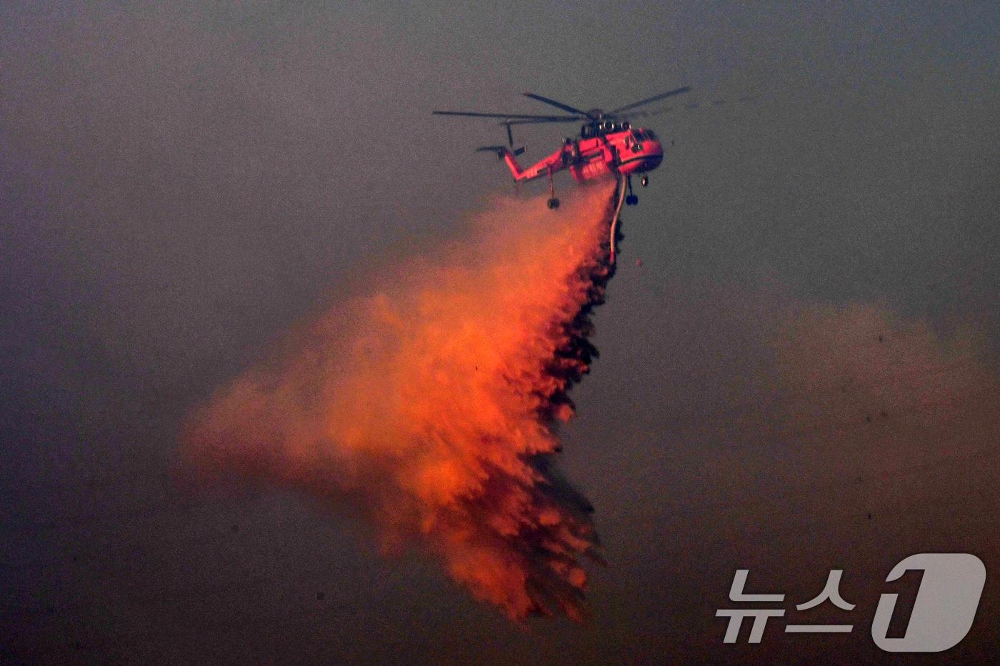 본문 이미지 - 8일 경북 경주시 문무대왕면 입천리에서 발생한 산불이 강풍을 타고 확산되고 있는 가운데 산림청 초대형헬기(S-64) 헬기가 송전선로를 피해 진화 작업을 벌이고 있다. 이날 오후 정부는 신속한 진화를 위해 국가소방동원령을 발령했다. 2026.2.8 ⓒ 뉴스1 최창호 기자
