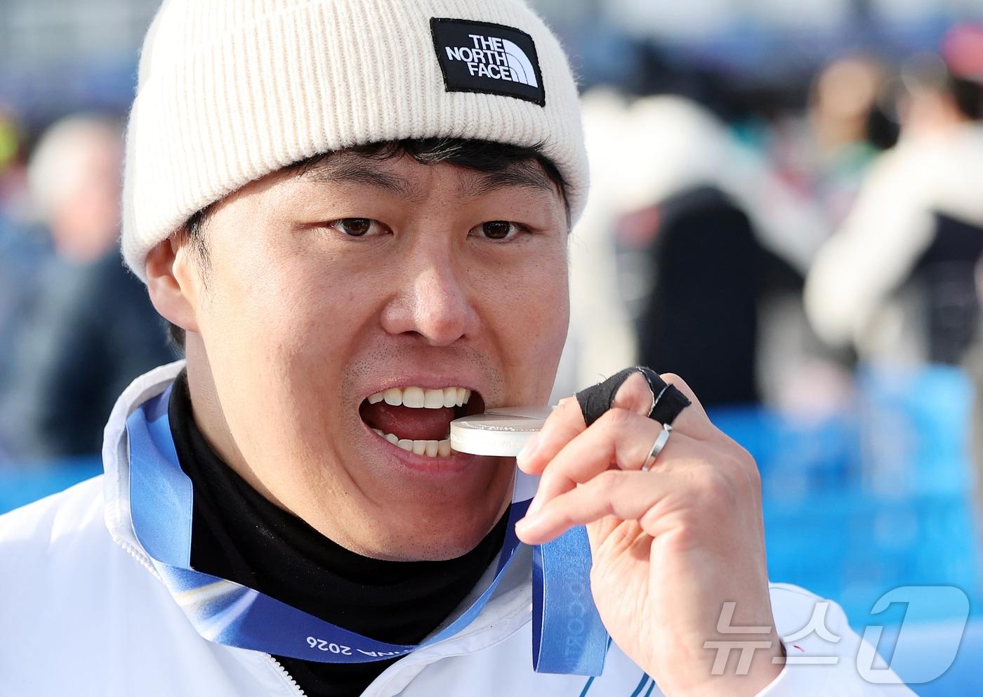 본문 이미지 - 스노보드 남자 평행 대회전에서 값진 은메달을 획득한 김상겸이 8일(현지시간) 이탈리아 리비뇨의 스노파크에서 열린 2026 밀라노·코르티나담페초 동계올림픽 스노보드 남자 평행 대회전 시상식을 마친 뒤 메달을 깨물며 기뻐하고 있다. 2026.2.8 ⓒ 뉴스1 김진환 기자