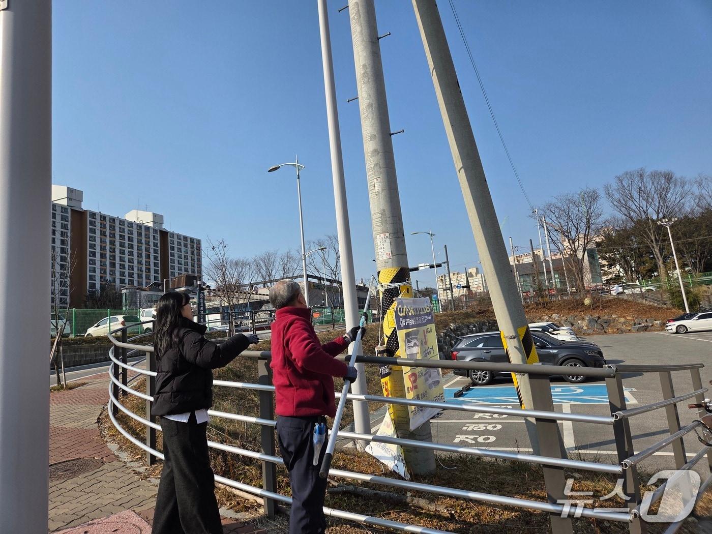 본문 이미지 - 계룡시가 다가오는 설 명절을 맞아 도시환경 개선을 위해 불법 현수막을 제거하고 있다. (계룡시 제공.재판매 및 DB금지)/뉴스1