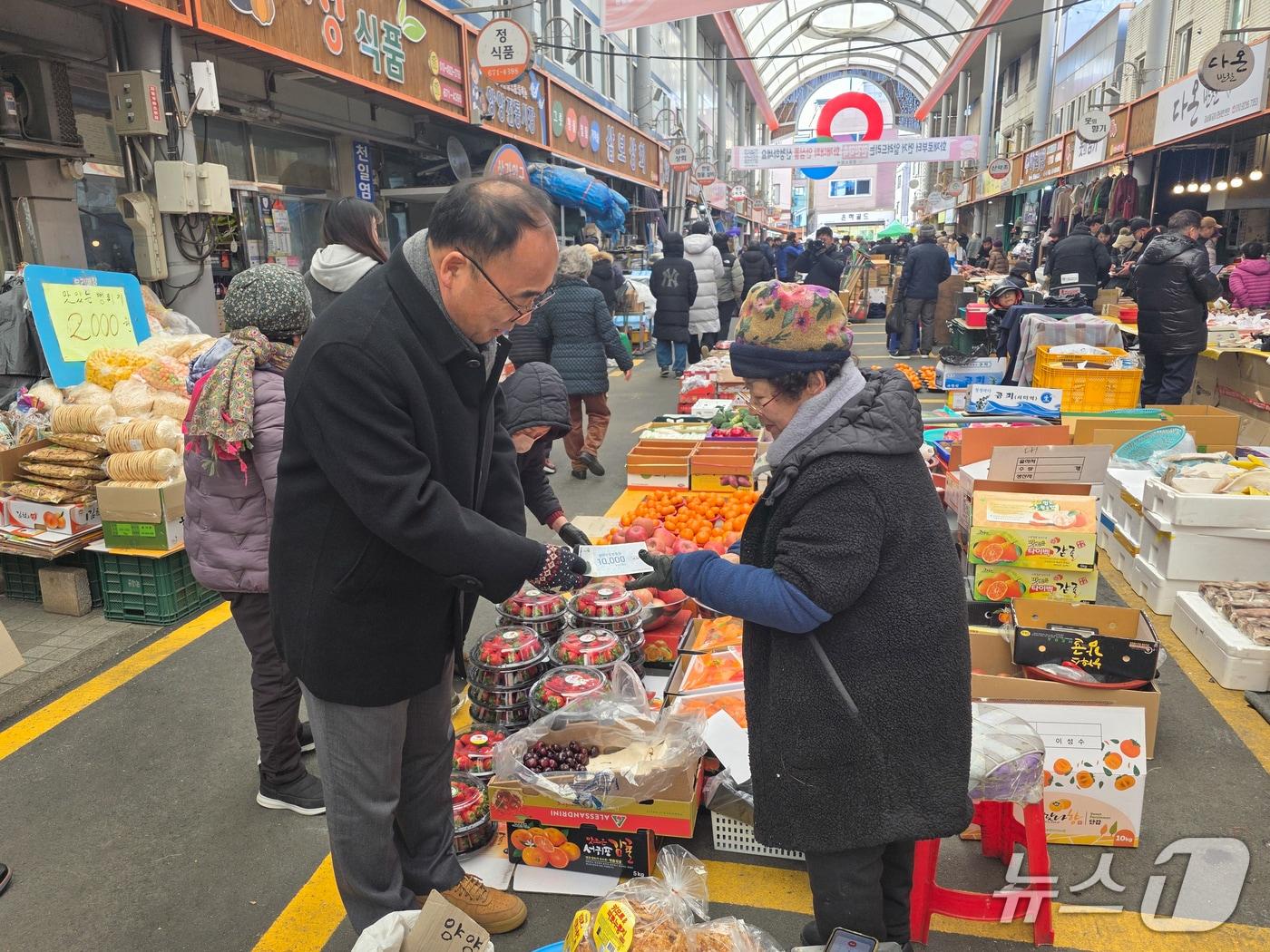본문 이미지 - 탁동수 강원 양양부군수가 9일 양양전통시장 일대에서 열린 전통시장 이용 캠페인에 참여해 물건을 구매하고 있다.(양양군 제공, 재판매 및 DB 금지) 2026.2.9/뉴스1
