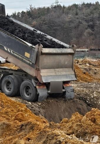 본문 이미지 - 울산 북구 상안동 동산마을의 한 농지에서 대형 덤프트럭이 공사장 폐기물로 추정되는 토사를 땅 속에 성토하고 있는 모습.(울산환경연합 제공. 재판매 및 DB금지)/뉴스1
