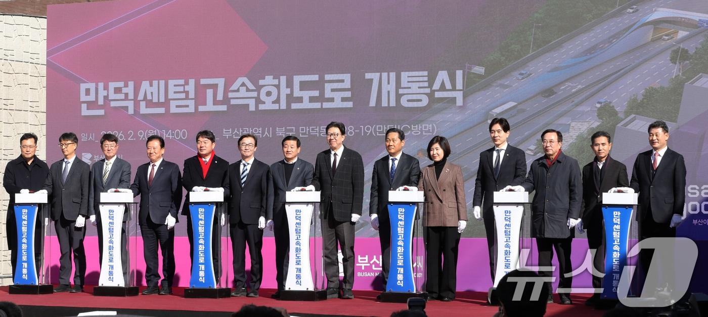 본문 이미지 - 9일 부산 북구 만덕IC 일원에서 열린 '만덕~센텀 도시고속화도로' 개통식에서 박형준 부산시장, 전재수 의원, 김미애 의원, 박성훈 의원 등 참석자들이 개통식 퍼포먼스를 하고 있다. 만덕∼센텀 도시고속화도로는 북구 만덕동과 해운대구 재송동을 연결하는 총연장 9.62km의 왕복 4차로의 터널로, 국내 최초 전차량 통행이 가능한 대심도 지하도로다. 2026.2.9 ⓒ 뉴스1 윤일지 기자