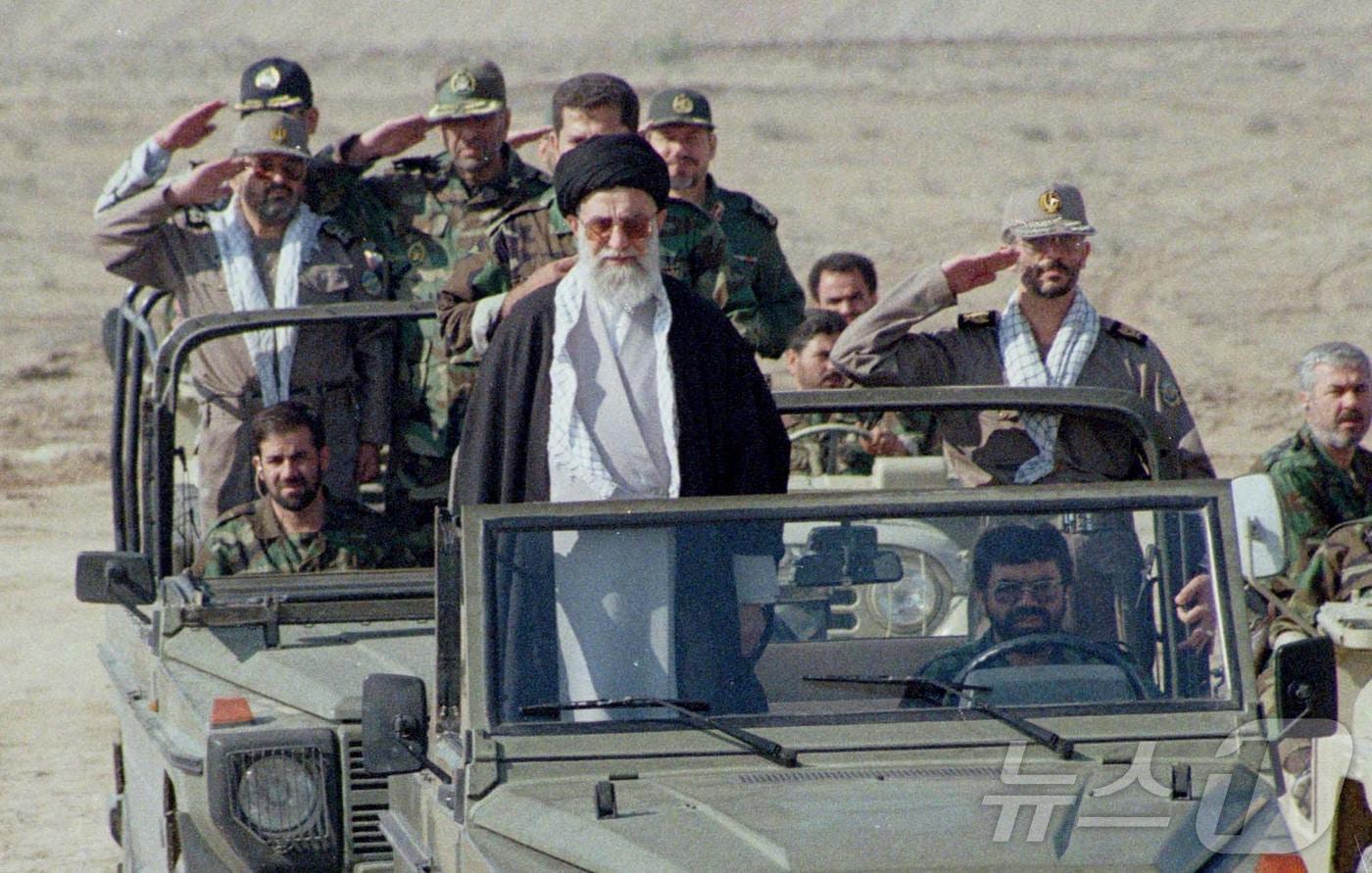 본문 이미지 - 지난 2020년 1월 20일 이란 최고지도자 아야톨라 알리 하메네이가 이스라엘에 맞서 팔레스타인를 지원하기 위한 훈련 중 11만 명의 민병대 자원병을 점검하며 지프 앞에 서 있다. 2020. 01. 20. ⓒ 로이터=뉴스1