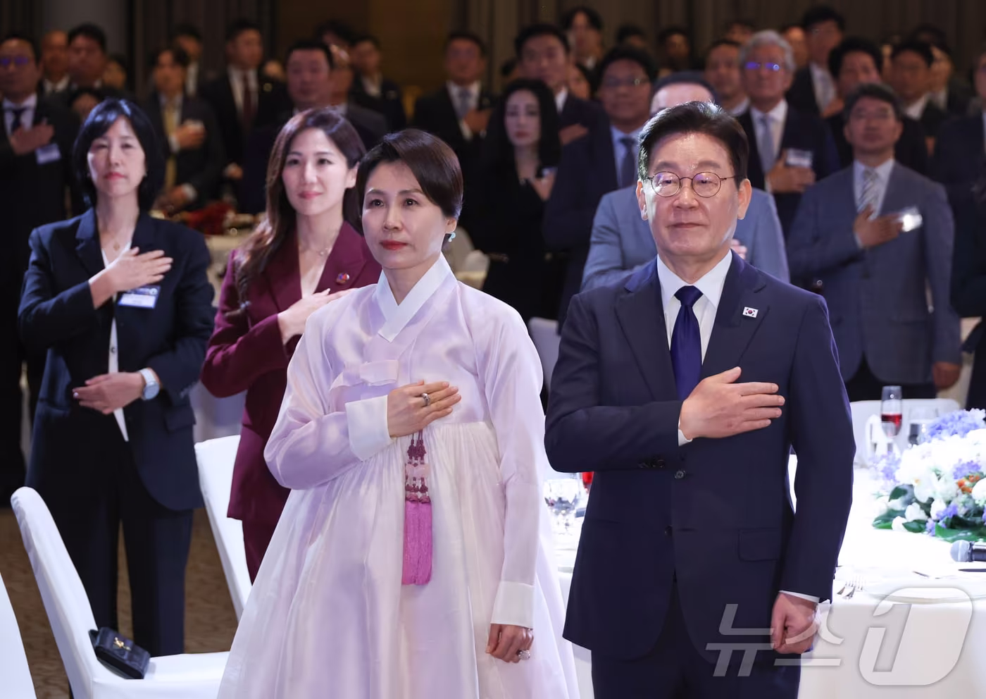 본문 이미지 - 싱가포르를 국빈 방문한 이재명 대통령과 김혜경 여사가 1일 싱가포르 한 호텔에서 열린 동포 만찬 간담회에서 국민의례를 하고 있다. 2026.3.1 ⓒ 뉴스1 허경 기자