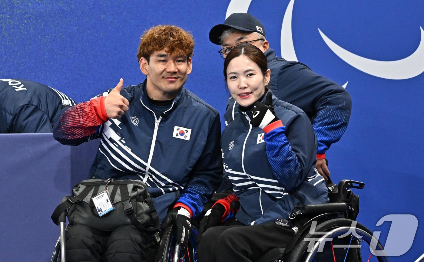 본문 이미지 - 휠체어컬링 이용석(왼쪽), 백혜진이 9일 오후(현지시간) 이탈리아 코르티나담페초 컬링 올림픽 스타디움에서 열린 2026 밀라노 코르티나 패럴림픽 휠체어컬링 믹스더블 에스토니아와의 경기에서 승리 후 포즈를 취하고 있다. 2026.3.10 ⓒ 뉴스1 사진공동취재단