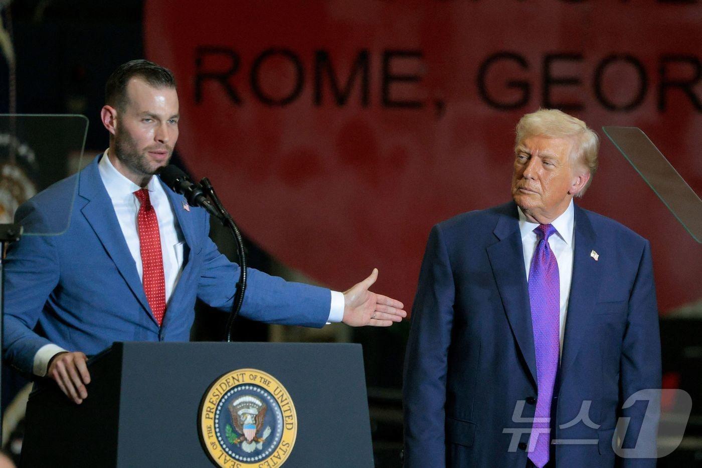 본문 이미지 - 도널드 트럼프 미국 대통령(오른쪽)이 2월 조지아주 로마에 위치한 쿠사 처강 회사에서 연설 중인 클레이 풀러 조지아주 제14선거구 공화당 후보를 지켜보고 있다. 2026.2.19 ⓒ AFP=뉴스1