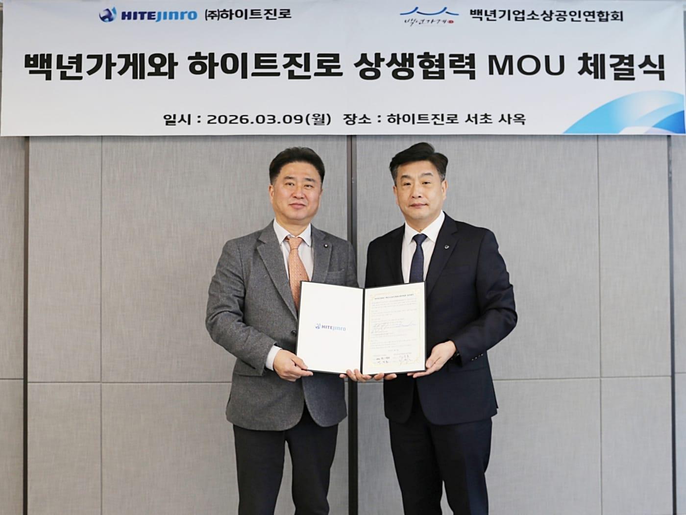 본문 이미지 - 9일 하이트진로 서초사옥에서 이광호 백년가게협동조합연합회 회장(왼쪽)과 백정훈 하이트진로 영업부문 상무가  '상생협력 업무협약(MOU)'을 체결 후 기념 촬영을 하는 모습.(하이트진로 제공)