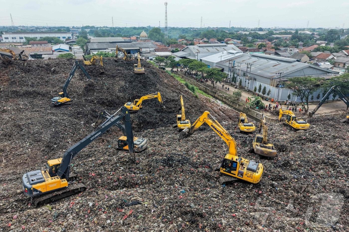 본문 이미지 - 9일(현지시간) 인도네시아 서자바 베카시의 반타르게방 매립지에서 발생한 산사태 이후 구조팀이 중장비를 이용해 실종자 수색 작업을 벌이고 있다. 2026.03.09. ⓒ AFP=뉴스1
