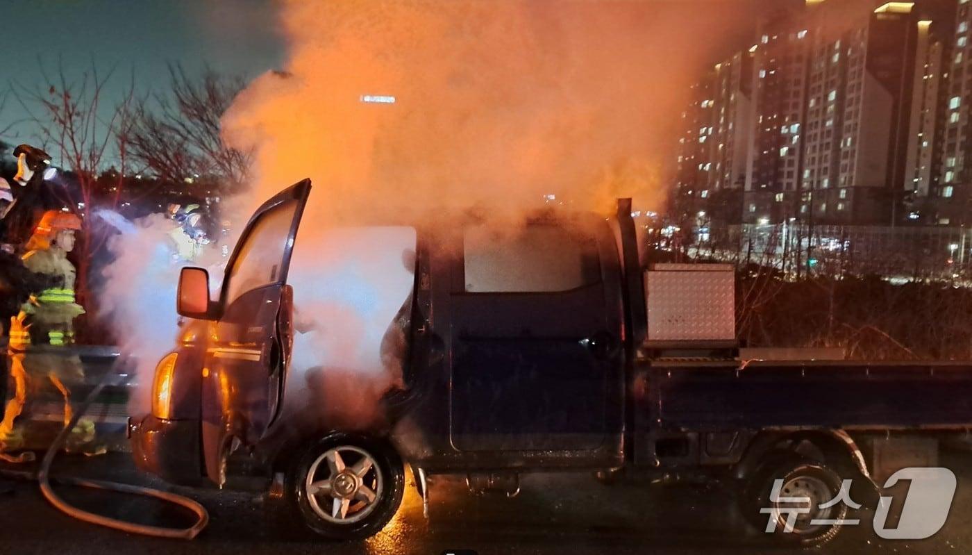 본문 이미지 - 10일 오후 7시51분쯤 경북 경산시 진량읍 선화리 경부고속도로 부산 방향 111.4㎞ 지점을 달리던 1톤 화물차에 불이나 소방대원들이 진화하고 있다.(경북소방본부 제공. 재판매 및 DB 금지)2026.3.11/뉴스1