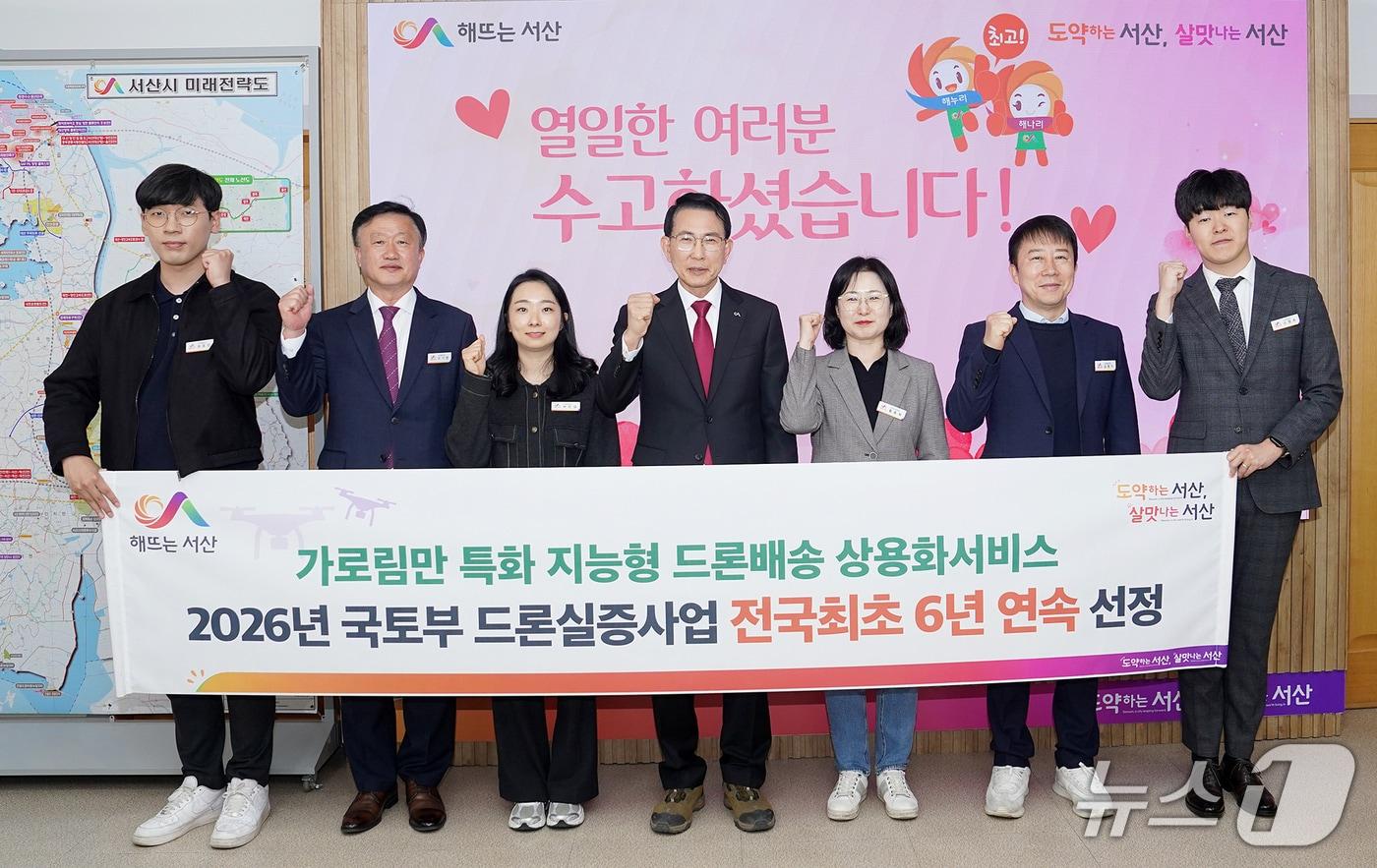 본문 이미지 - 이완섭 서산시장(가운데)과 관계 공무원들이 시청 시장실에서 드론 실증도시 구축사업 6년 연속 선정을 축하하며 기념촬영을 하고 있다.(서산시 제공. 재판매 및 DB금지)2026.3.12/뉴스1