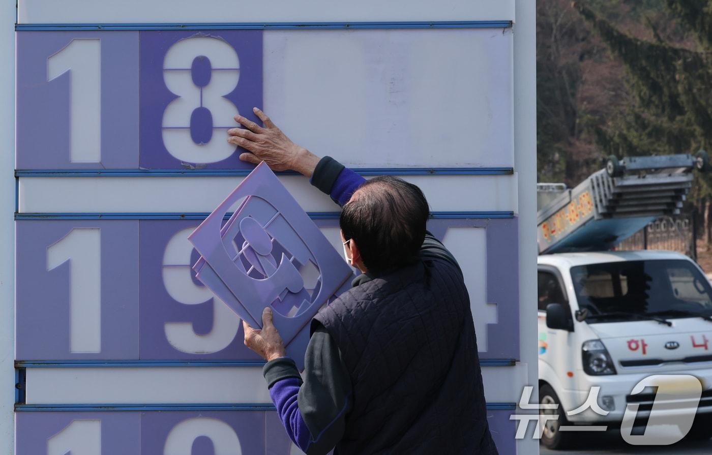 본문 이미지 - 중동 전쟁 여파로 고공행진을 이어가던 주유소 기름값이 소폭 하락한 가운데 12일 오전 대전 유성구 한 주유소에서 관계자가 휘발유와 경유 가격표를 조정하고 있다. 이 주유소는 휘발유 가격을 리터당 1984원에서 1894원으로 내렸다. 2026.3.12 ⓒ 뉴스1 김기태 기자