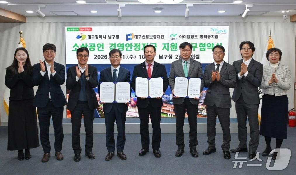 본문 이미지 - 박진우 대구신용보증재단 이사장(왼쪽 네번째)과 조재구 남구청장(가운데)이 소상공인 경영안정자금 지원을 위한 업무협약을 체결한 뒤 협약서를 펼쳐 보이고 있다.(대구신보 제공. 재판매 및 DB 금지)