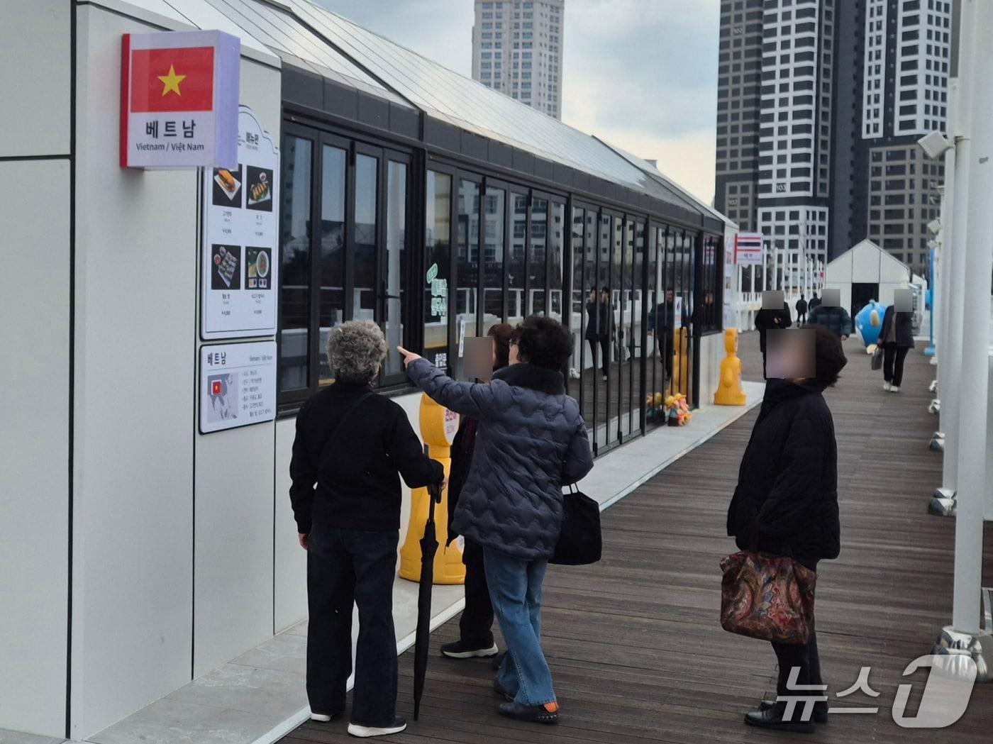 본문 이미지 - 울산 시민들이 12일 울산교 세계음식문화관에서 베트남 음식점 메뉴판을 보고 있다.2026.3.12/뉴스1ⓒ 뉴스1 박정현 기자