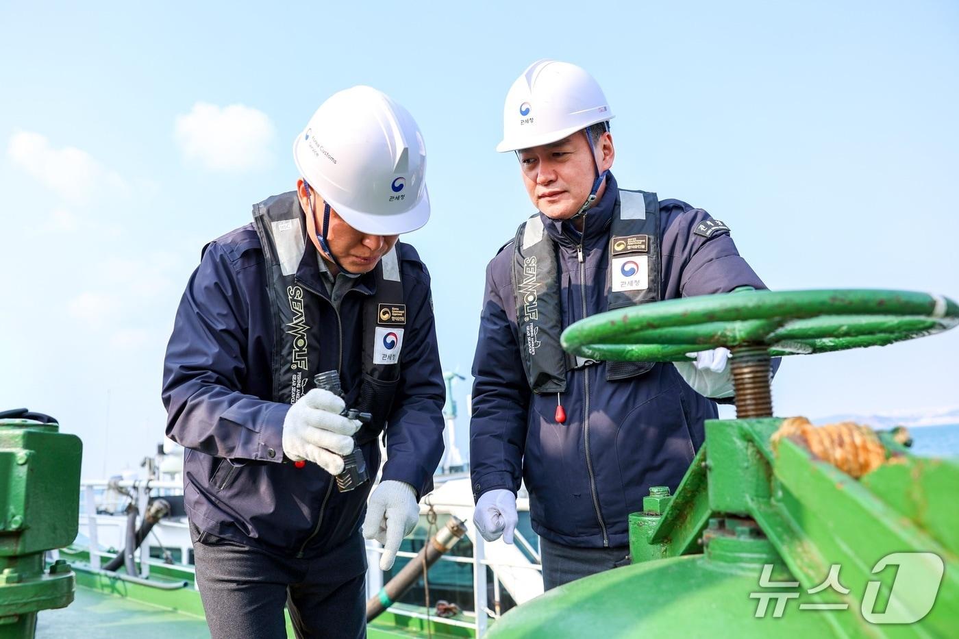 본문 이미지 - 관세청 중동상황 비상대응 TF 단장인 이종욱 차장(오른쪽)이 부산항에 입항한 국제무역선의 전반적인 해상면세유 공급 체계를 점검하고 있다. (관세청 제공.재판매 및 DB금지)/뉴스1