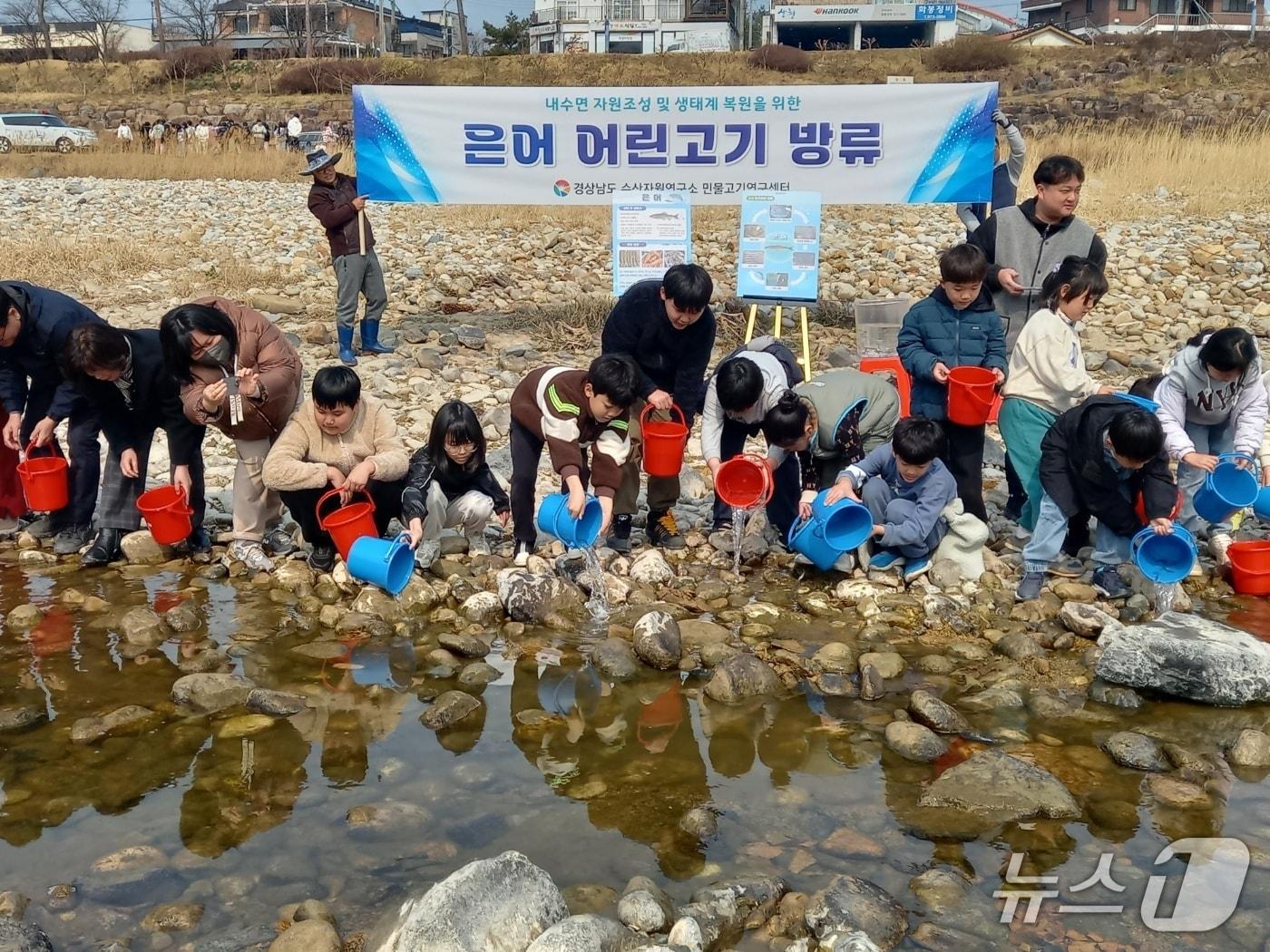 본문 이미지 - 12일 산청군 경호강에서 열린 은어 방류 행사에서 어린이들이 은어를 방류하고 있다.(경남도 제공. 재판매 및 DB금지)