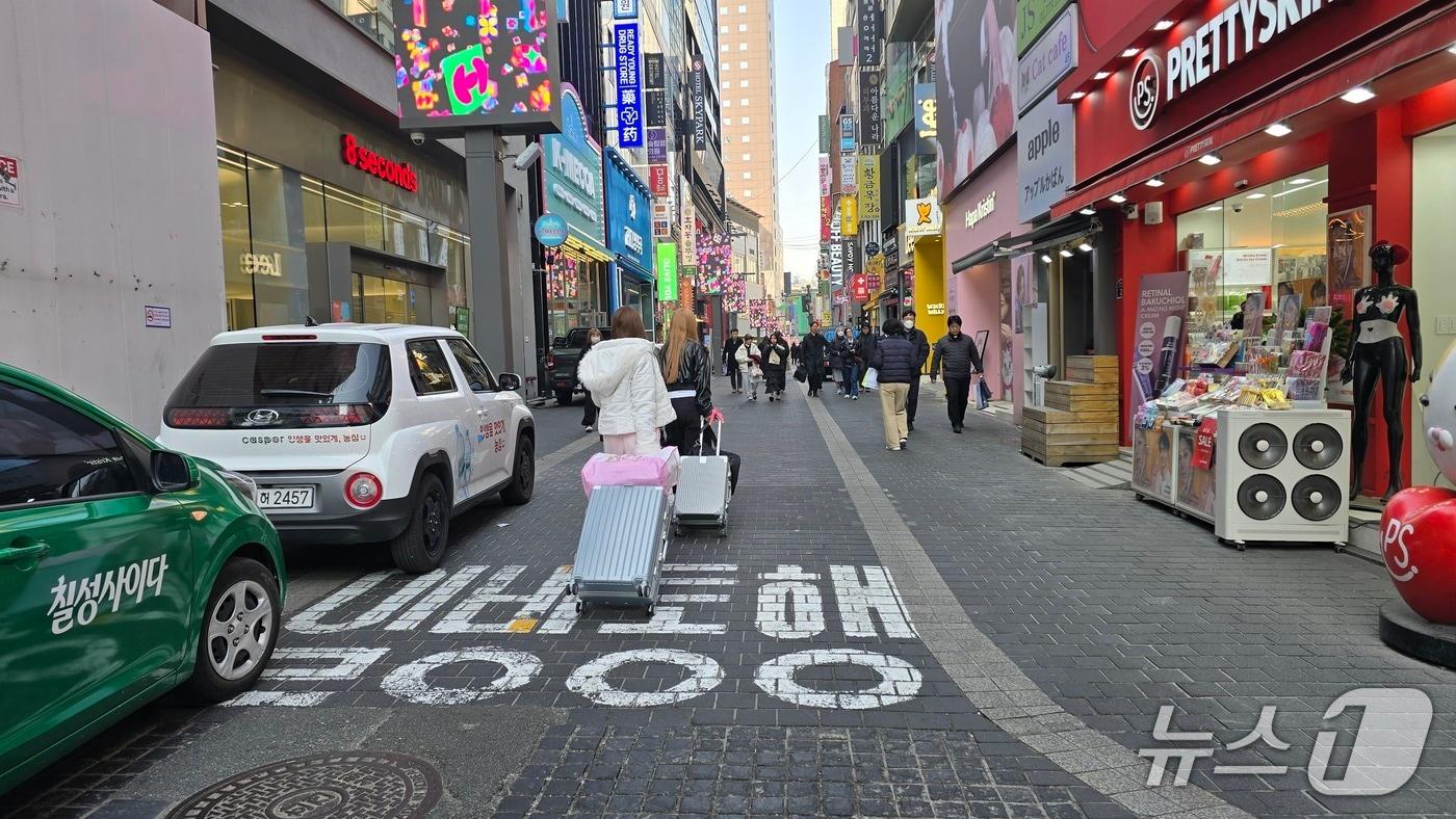 본문 이미지 - 12일 서울 중구 명동역 인근 상점가에서 외국인 관광객 2명이 캐리어를 끌고 가는 모습./뉴스1 ⓒNews1 소봄이 기자.