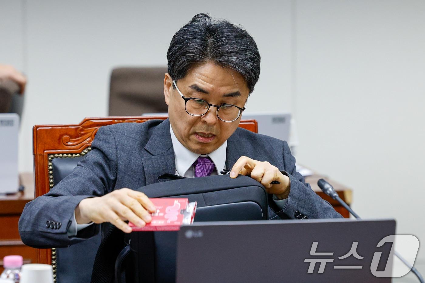 본문 이미지 - 12일 오후 서울 양천구 방송미디어통신심의위원회에서 열린 2026년 제1차 방미심위 정기 회의에서 언론노조로부터 사퇴 압박을 받고 있는 김우석 위원이 위장약을 꺼내고 있다. 2026.3.12 ⓒ 뉴스1 안은나 기자