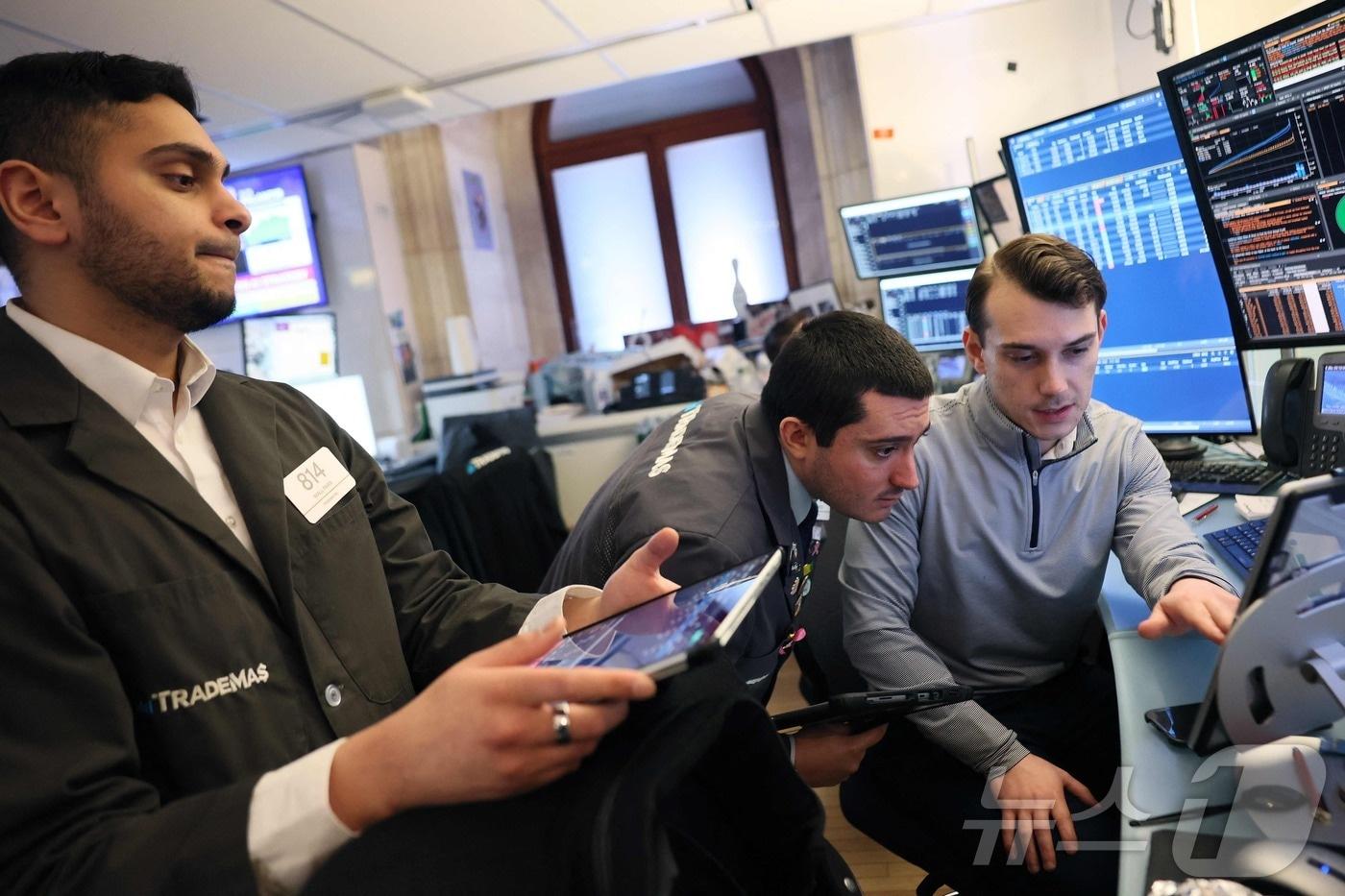 본문 이미지 - 12일(현지시간) 뉴욕증권거래소(NYSE) 트레이딩 플로어에서 트레이더들이 장중 거래를 진행하고 있다.2026.3.12ⓒ AFP=뉴스1