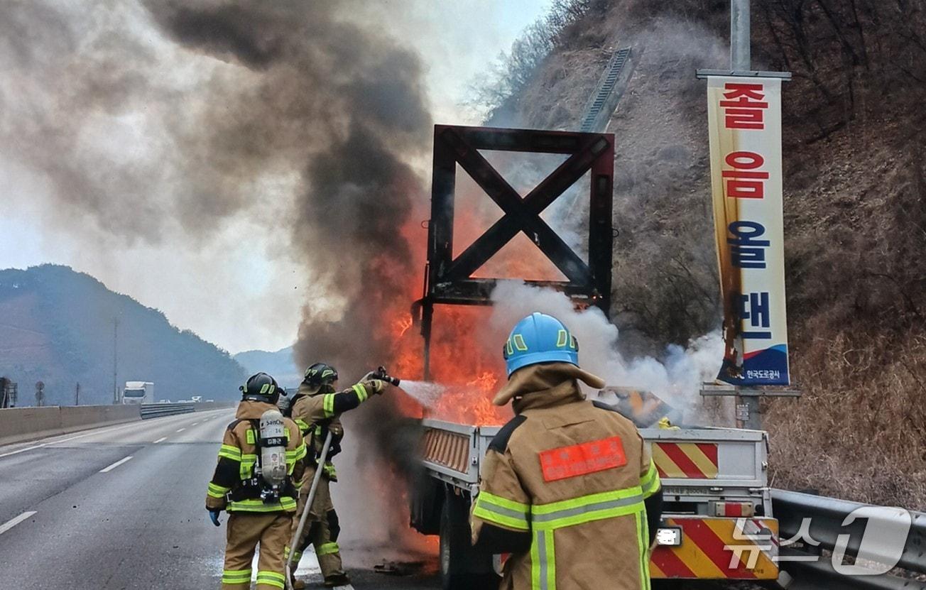 본문 이미지 - 12일 오후 2시 5분쯤 경북 문경시 불정동 중부내륙고속도로 창원 방향 172.4㎞지점에서 도로보수 작업 차량에 불이 나 진화대원들이 불을 끄고 있다.(경북소방본부 제공. 재판매 및 DB금지)2026.3.13/뉴스1