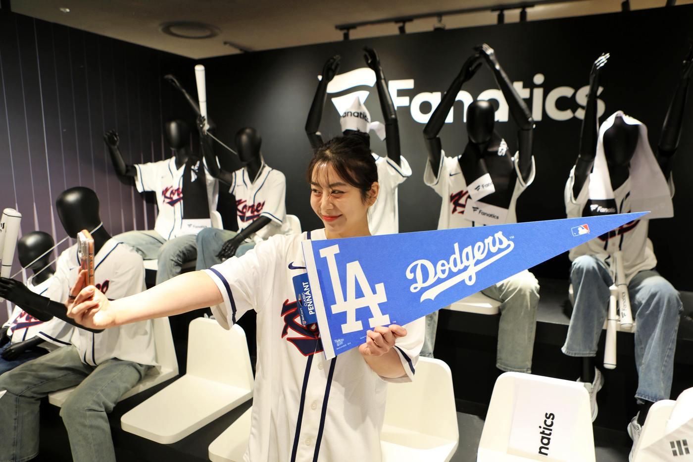 본문 이미지 - 서울시 송파구에 위치한 에비뉴엘 잠실점 지하 1층에서 열린 파나틱스 팝업스토어에서 고객이 WBC 및 MLB 굿즈를 둘러보는 모습.(롯데백화점 제공)