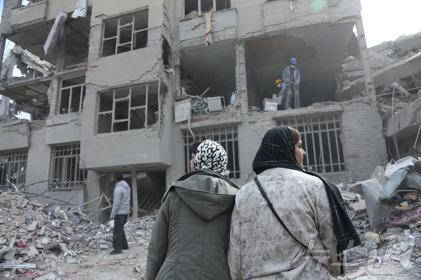 본문 이미지 - 12일(현지시간) 이란 수도 테헤란의 폐허 속에서 주민들이 폭격에 손상된 건물을 뒤져 생필품을 찾고 있다. 2026.3.12 ⓒ 신화=뉴스1