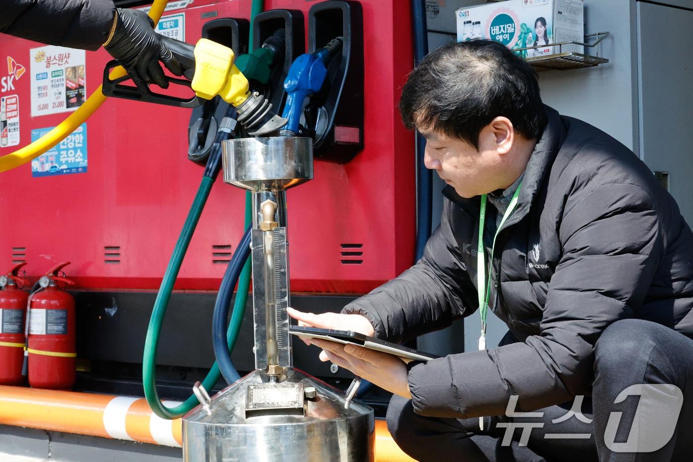 본문 이미지 - 석유 최고가격제 시행 첫날인 13일 서울 마포구 SK에너지 양지주유소에서 한국석유관리원 관계자들이 정량기준탱크를 통해 휘발유 정량 확인을 하고 있다. ⓒ 뉴스1 안은나 기자