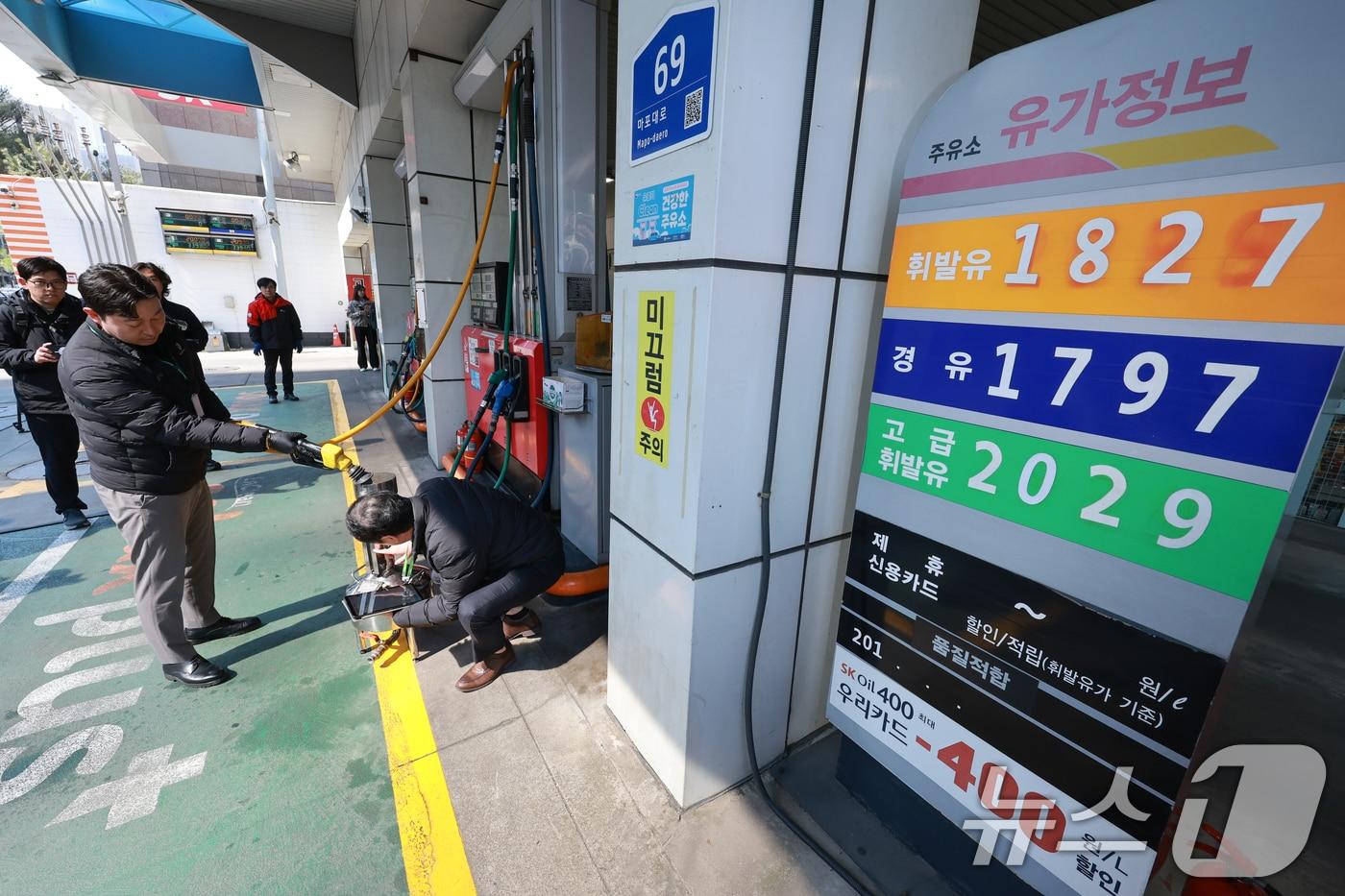 본문 이미지 - 석유 최고가격제 시행 첫날인 13일 서울 마포구 SK에너지 양지주유소에서 한국석유관리원 관계자들이 정량기준탱크를 통해 휘발유 정량 확인을 하고 있다. 2026.3.13 ⓒ 뉴스1 안은나 기자