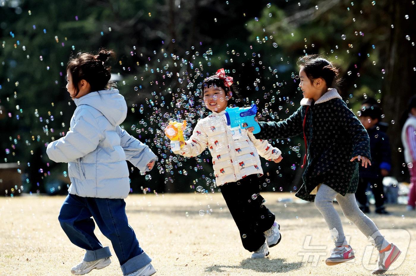본문 이미지 - 초봄 날씨를 보인 13일 광주 북구청직장어린이집 아이들이 전남대학교 캠퍼스 잔디 광장에서 포근한 봄 햇살 아래 비눗방울 놀이를 하며 즐거운 시간을 보내고 있다. (광주 북구 제공. 재판매 및 DB 금지) 2026.3.13 