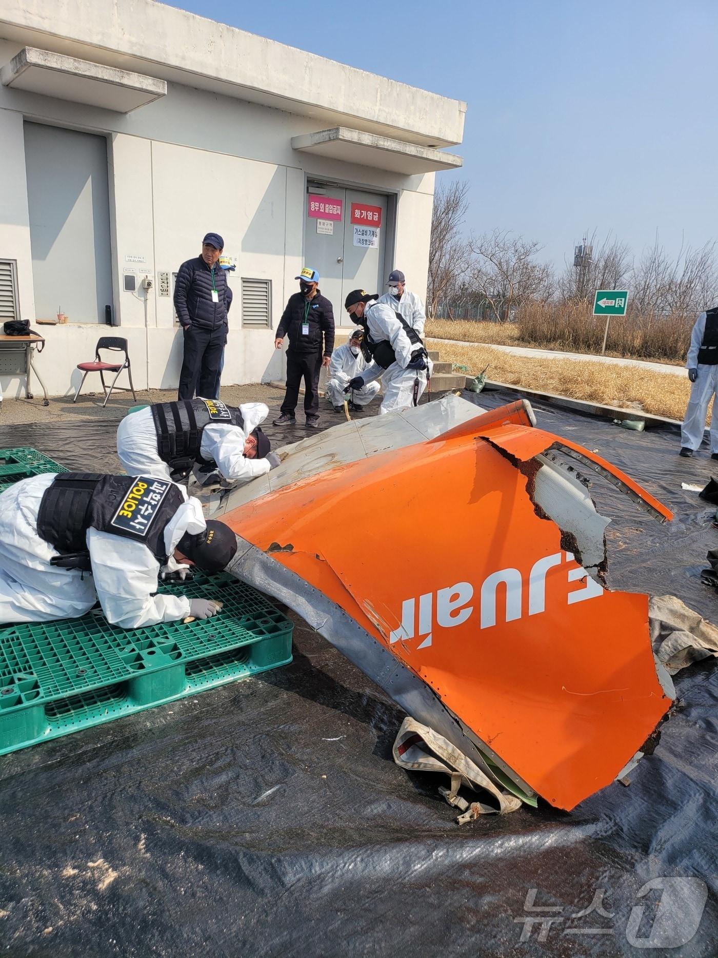본문 이미지 - 지난 12일 진행된 무안국제공항국 기체잔해 보관서에서  국토부 관계자와 전남청 과학수사계, 항철위 일부 위원들이 제주항공 사고기 재분류 작업하고 있다. 