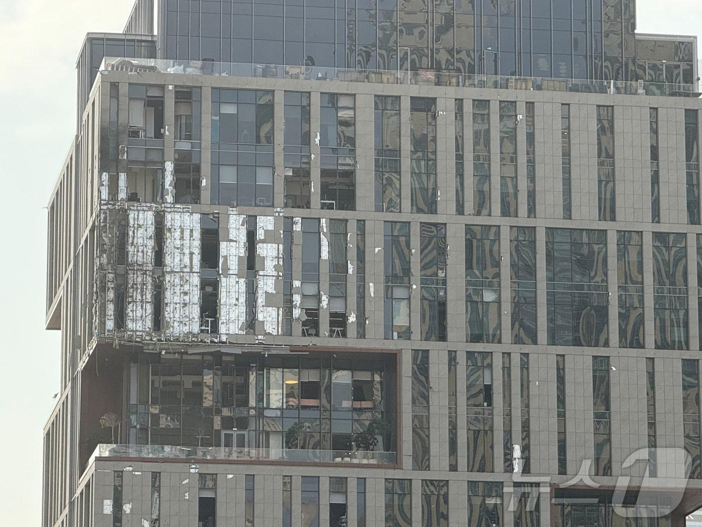 본문 이미지 - 두바이 국제금융지구(DIFC)의 건물이 이란 드론 파편으로 훼손된 모습. 2026.03.13. ⓒ 로이터=뉴스1