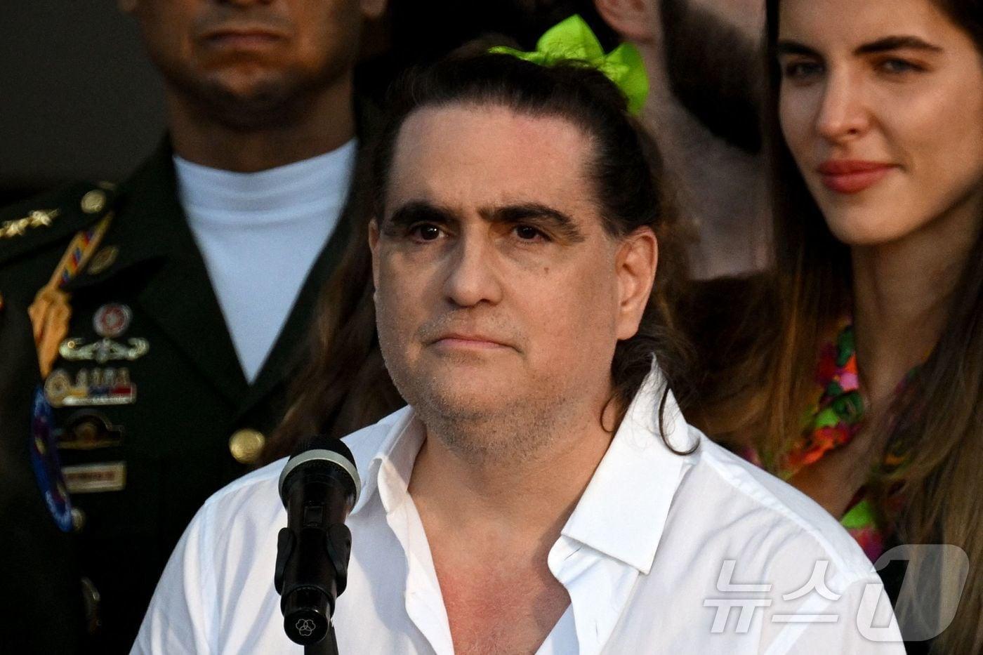 본문 이미지 - 콜롬비아 출신 사업가 알렉스 사브가 2023년 12월 20일 카라카스 미라플로레스 대통령궁에서 아내 카밀라 파브리(오른쪽)와 함께 발언하고 있다. 2023.12.20.ⓒ AFP=뉴스1