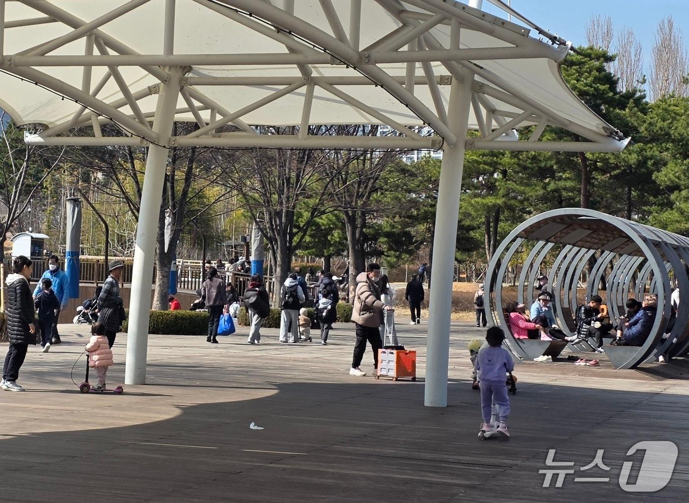 본문 이미지 - 14일 오후 부산시민공원 연못 인근에서 시민들이 이동하고 있다.2026.3.14/뉴스1 ⓒ News1 장광일 기자