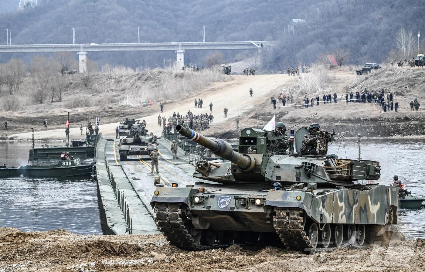 본문 이미지 - 경기도 연천군 일대에서 실시된 한미연합 제병협동훈련에서 K1A2 전차가 한국군 자주도하장비 수룡(KM3)과 미국 개량형 전술부교(IRB)가 결합한 연합부교를 통해 도하하고 있다. (육군 제공. 재판매 및 DB 금지) 2026.3.14 ⓒ 뉴스1