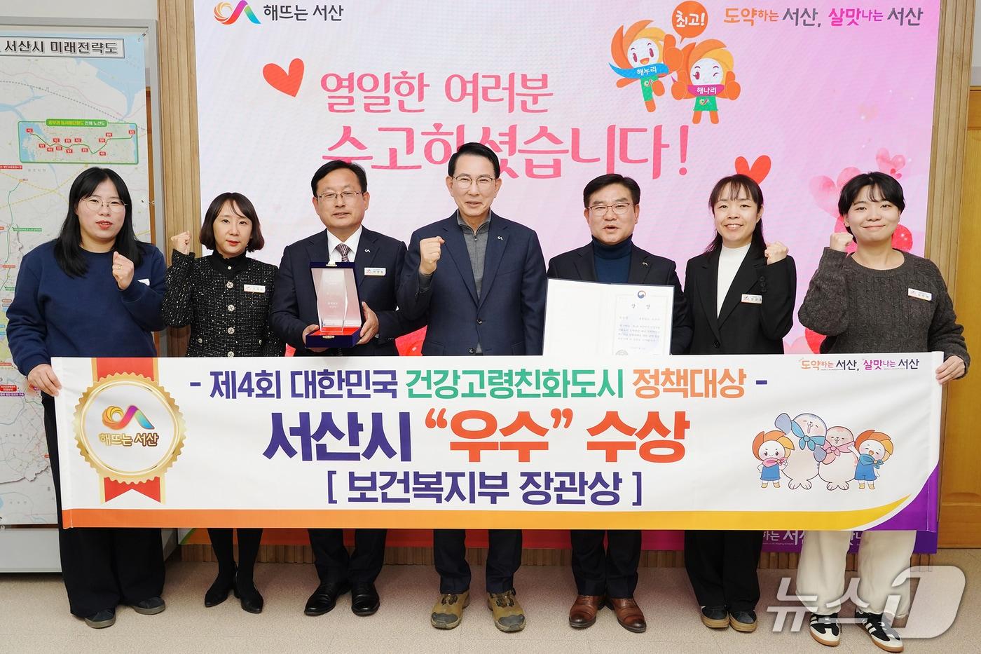 본문 이미지 - 이완섭 서산시장(가운데)과 관계 공무원들이 제4회 대한민국 건강고령친화도시 정책대상에서 우수기관에 선정된 것을 축하하며 기념촬영을 하고 있다.(서산시 제공. 재판매 및 DB금지)2026.3.16/뉴스1