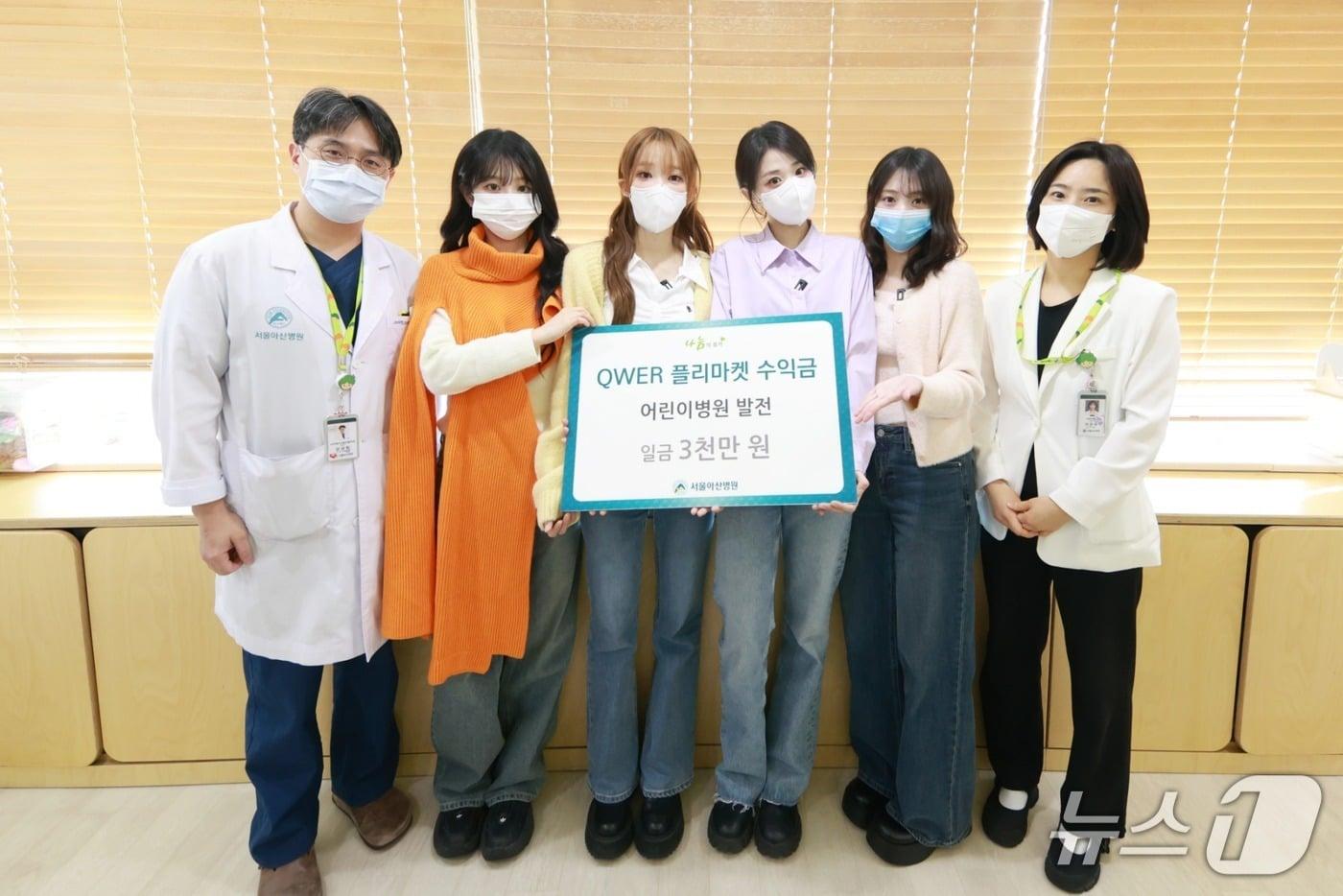 본문 이미지 - 그룹 QWER이 서울아산병원 어린이병원에 3000만 원을 최근 후원했다. 소아청소년종양혈액과 강성한 교수(왼쪽)를 비롯한 의료진이 QWER과 기념촬영을 하고 있다.(서울아산병원 제공)