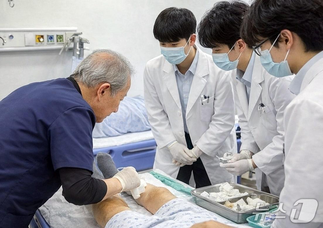 본문 이미지 - 인하대 의대는 의학교육 혁신을 위한 ‘지역사회기반 의학교육’ 과정으로 백령병원, 병원선 등에서 특성화 임상 실습을 하고 있다. 백령병원 이두익 원장이 인하대 의대 본과 4학년 학생들을 대상으로 응급실 환자 교육을 하고 있는 모습.(인하대 제공. 재배포 및 DB금지)2026.3.16/뉴스1