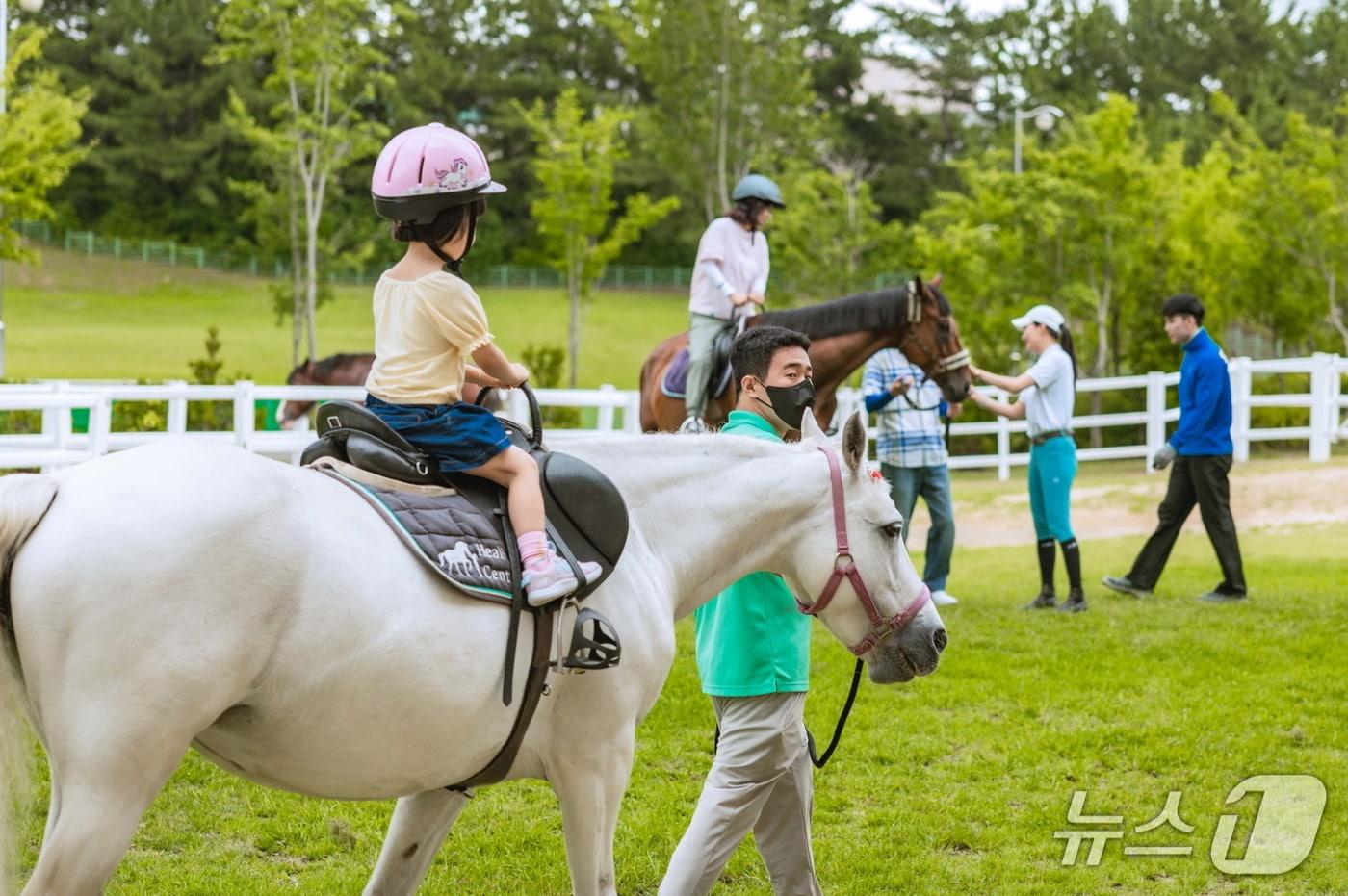 본문 이미지 - 한 어린이가 홀스테라피 프로그램에서 말과 교감하고 있다.(한국마사회 렛츠런파크 부산경남 제공. 재판매 및 DB금지)