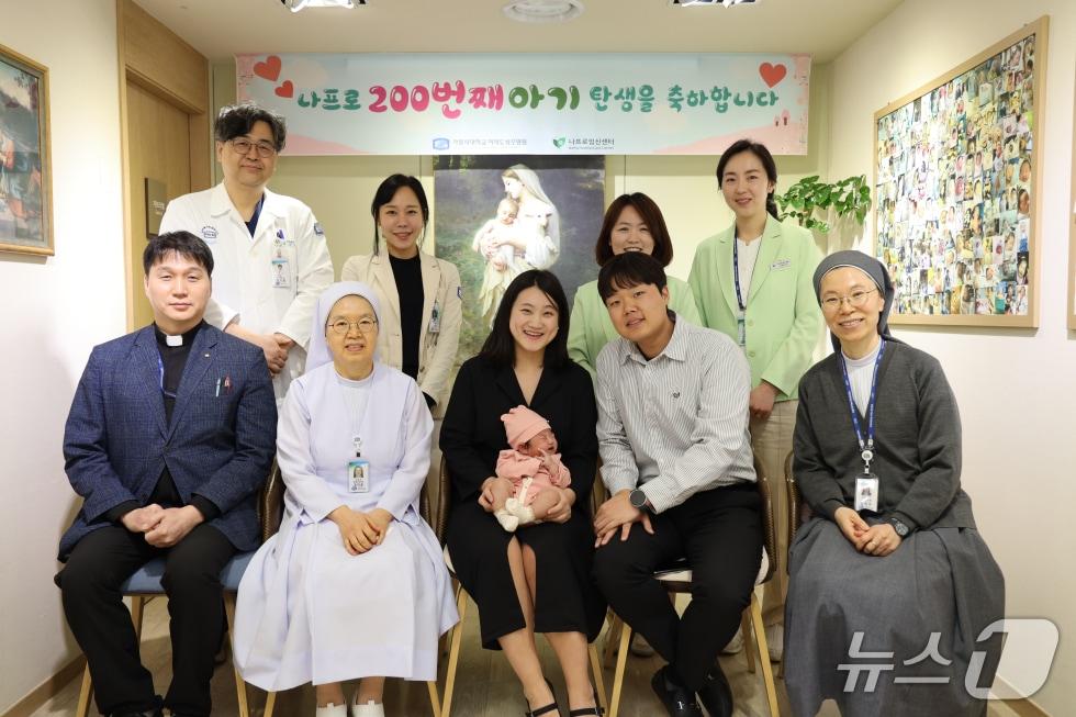 본문 이미지 - 가톨릭대 여의도성모병원 나프로임신센터가 나프로임신법 200번째 출산 주인공인 정씨 부부와 함께 지난 13일 아기 탄생을 축하하며 기념 촬영을 하고 있다.(가톨릭대 여의도성모병원 제공)