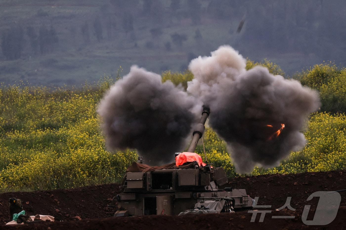 본문 이미지 - 15일(현지시간) 이스라엘군의 한 포병 부대가 이스라엘 북부 레바논 접경 지역에서 포격을 하고 있다. 2026.03.15 ⓒ 로이터=뉴스1