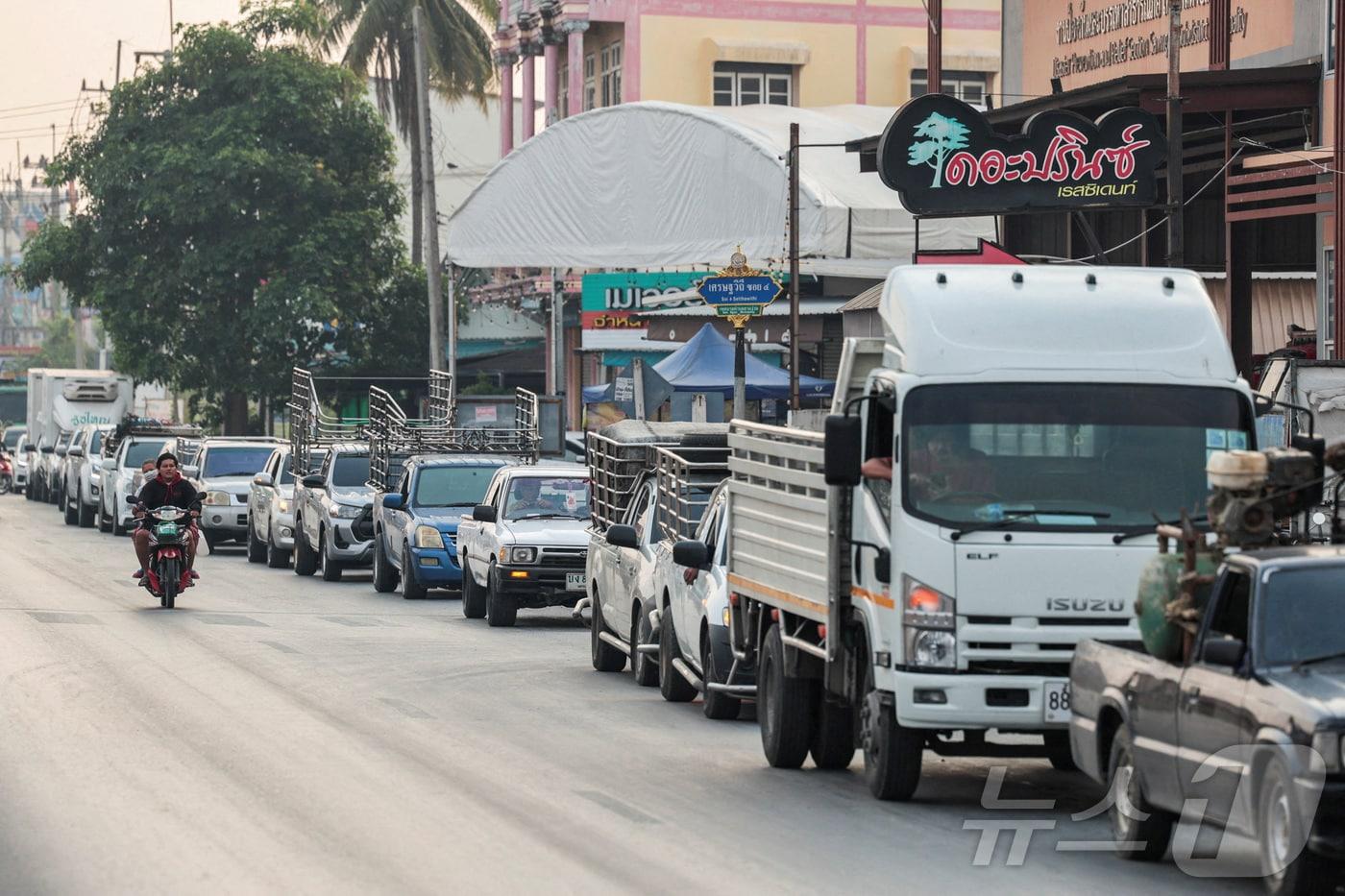 본문 이미지 - 2026년 3월 16일 태국 방콕 외곽 나콘파톰 주에서 운전자들이 차량에 연료를 주입하기 위해 주유소 앞 도로에 줄지어 서 있다. 2026.03.16. ⓒ 로이터=뉴스1