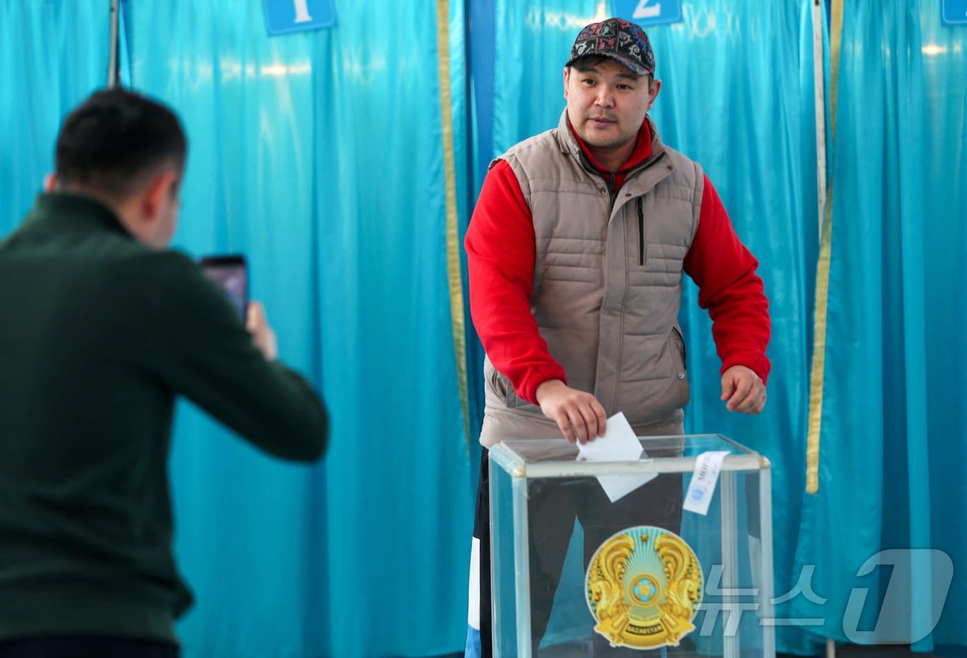 본문 이미지 - 카자흐스탄의 알마티에서 한 시민이 15일 개헌안 국민투표에 참여하고 있다. 2026.3.15 ⓒ 로이터=뉴스1