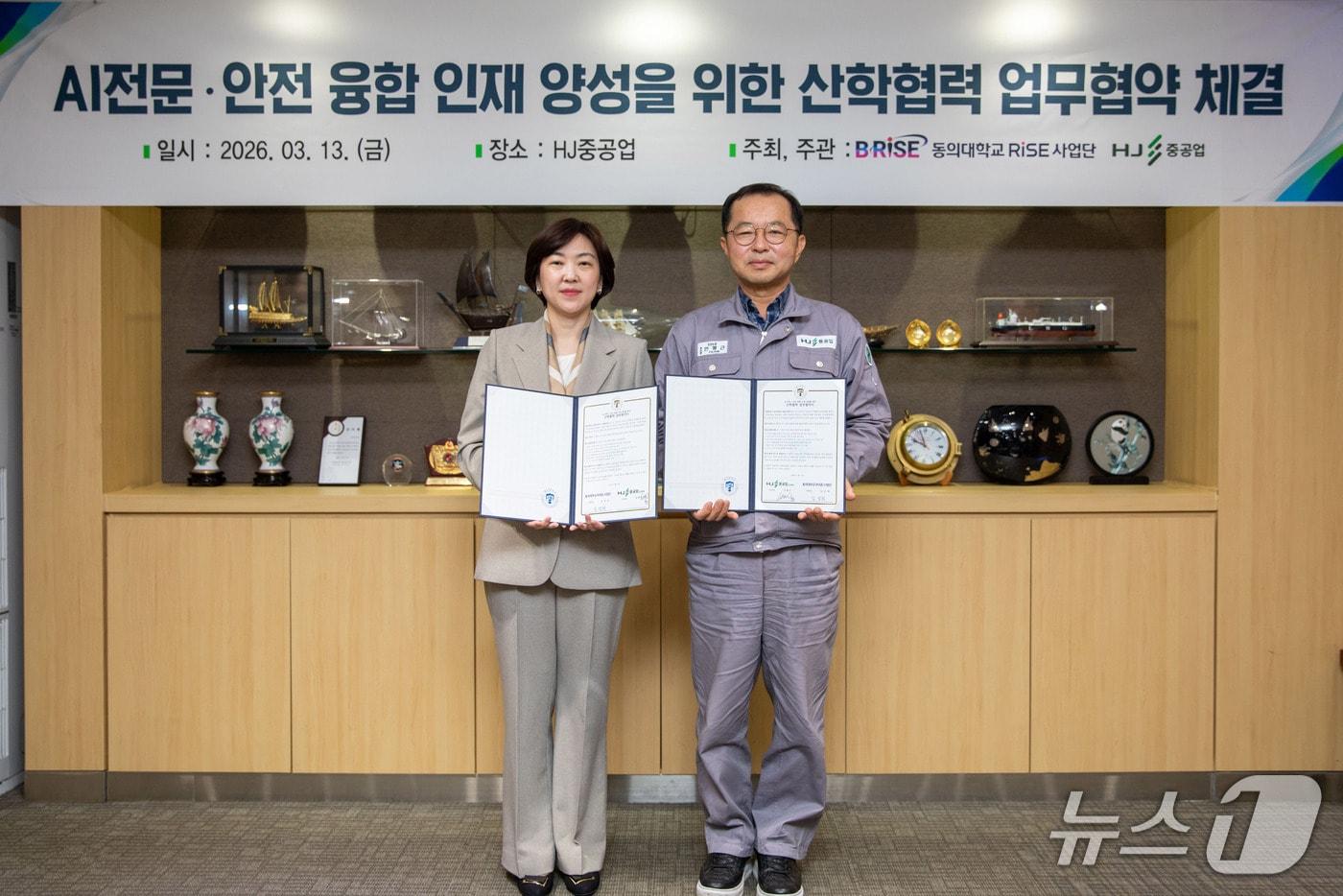 본문 이미지 - HJ중공업에서 열린 AI전문·안전 융합 인재 양성을 위한 산학협력 업무 협약식에서 김성희 동의대 RISE사업단장(왼쪽)과 안평근 HJ중공업 조선소장이 협약서를 들어보이고 있다. (동의대 제공. 재판매 및 DB 금지)