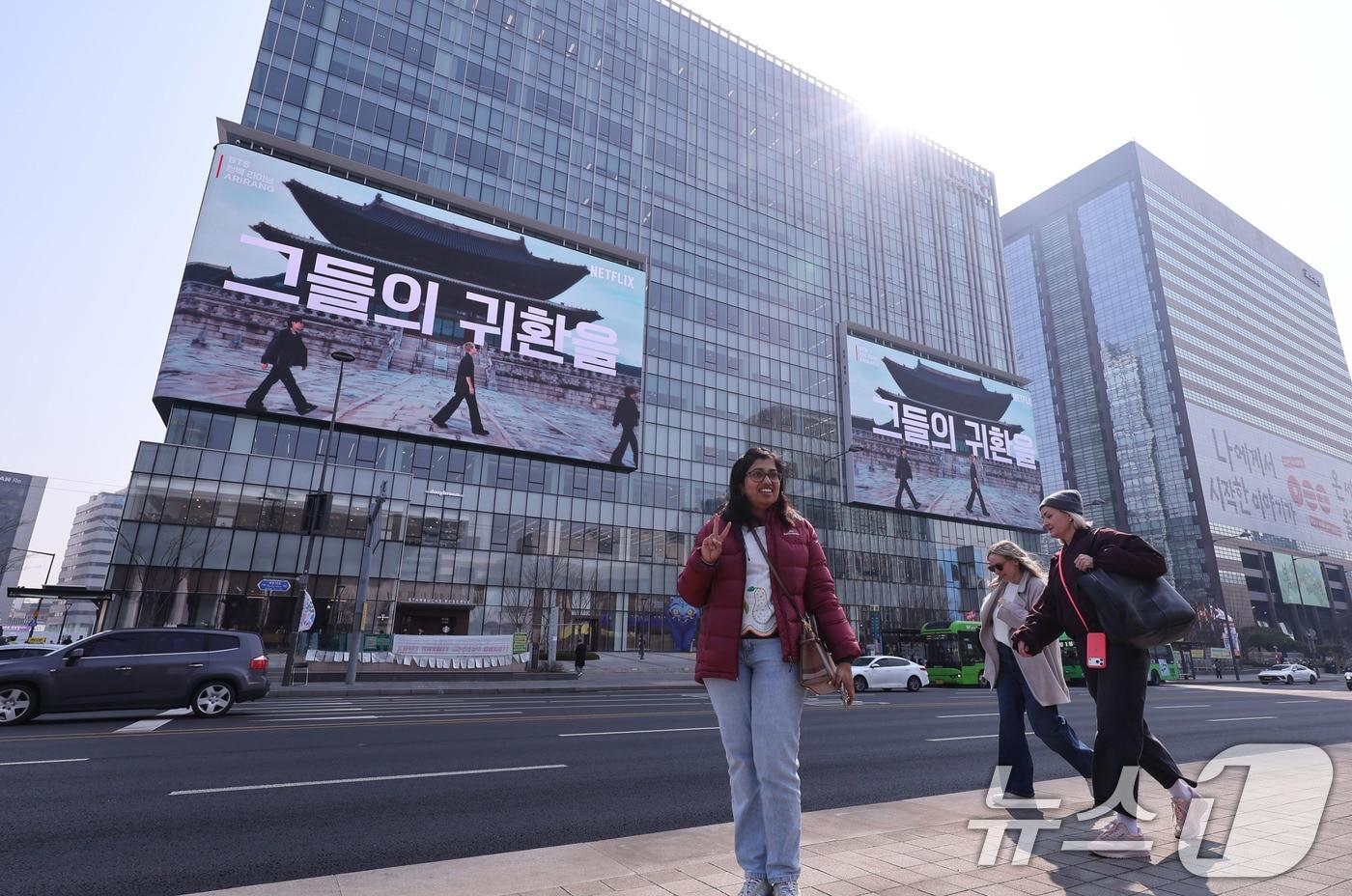 본문 이미지 - 방탄소년단(BTS) 완전체 컴백 공연을 나흘 앞둔 17일 오전 서울 광화문광장에서 외국인 관광객들이 기념 촬영을 하고 있다. 2026.3.17 ⓒ 뉴스1 박지혜 기자