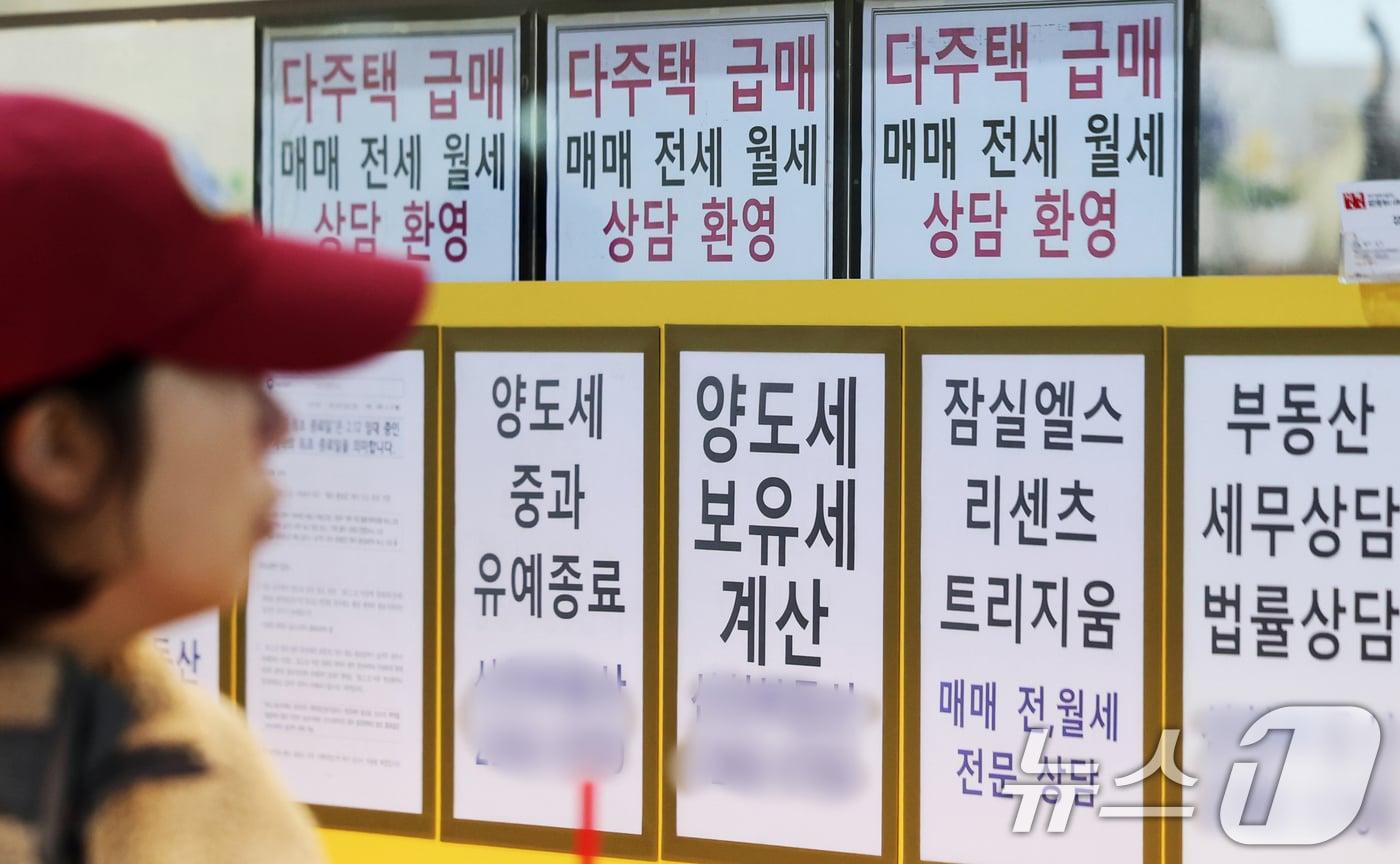 본문 이미지 -  서울 시내의 한 공인중개사 사무소 앞을 시민들이 지나가고 있다.  ⓒ 뉴스1 황기선 기자