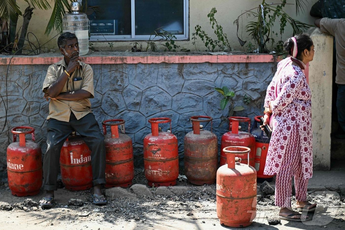 본문 이미지 - 11일(현지시간) 인도 첸나이의 한 가스 판매점에서 사람들이 가정용액화석유가스(LPG) 가스통를 사기 위해 줄을 서 있다. 2026.03.11. ⓒ AFP=뉴스1