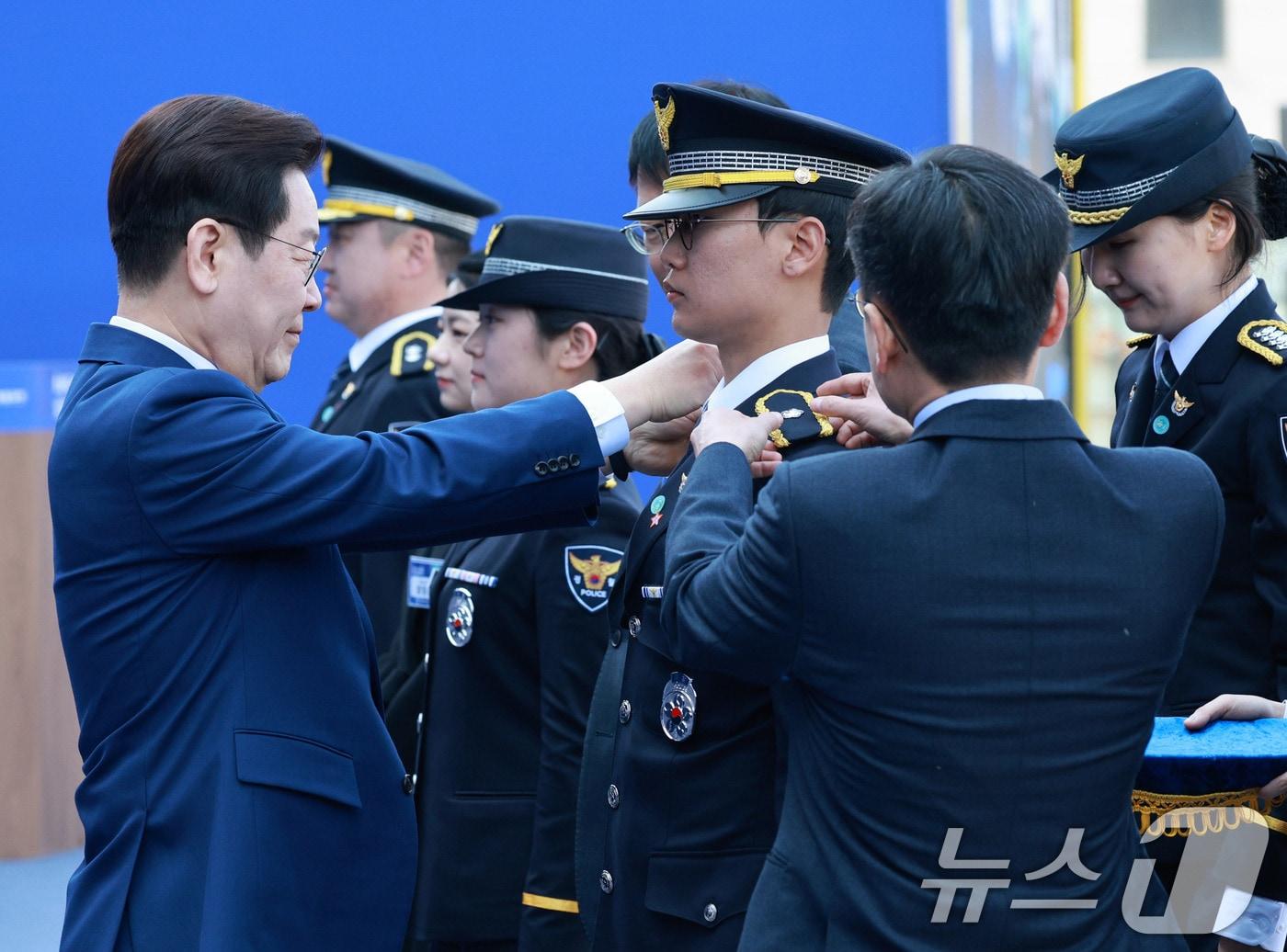 본문 이미지 - 이재명 대통령이 지난 17일 충남 아산시 경찰대학에서 열린 신임 경찰 경위·경감 임용식에서 계급장을 수여하고 있다. (청와대통신사진기자단) 2026.3.17 ⓒ 뉴스1 이재명 기자